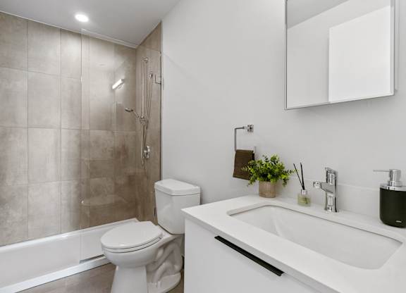 A white toilet sits next to a white sink in a bathroom.
