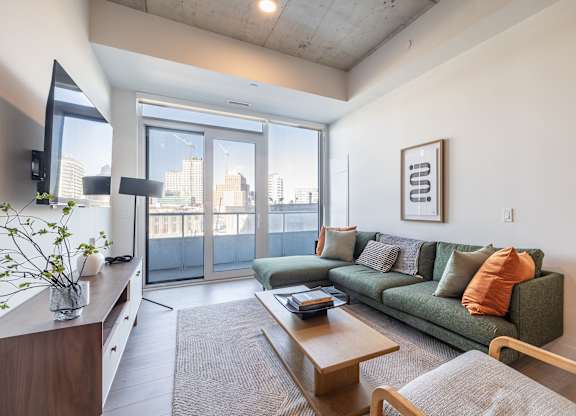 A living room with a green couch and a wooden coffee table.