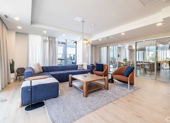 A modern living room with a blue sofa and wooden coffee table.