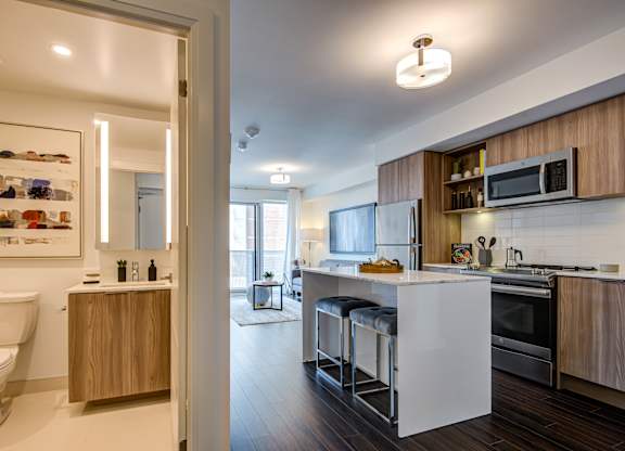 A modern kitchen with a white countertop and wooden cabinets.