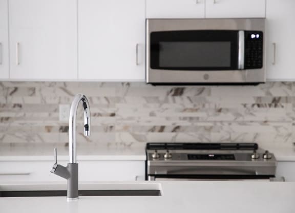 a white kitchen with a sink and a microwave