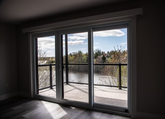 a living room with large windows and a view of a lake and trees