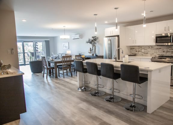 a kitchen with an island and a dining room with a table and chairs