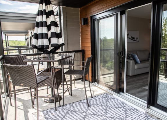 a patio with a table and chairs and sliding glass doors