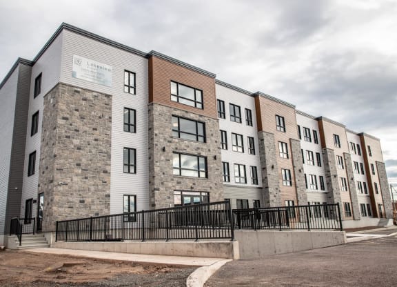 the exterior of a new apartment building on a cloudy day