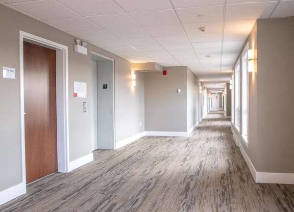 a hallway with wood floors and white walls and wooden doors