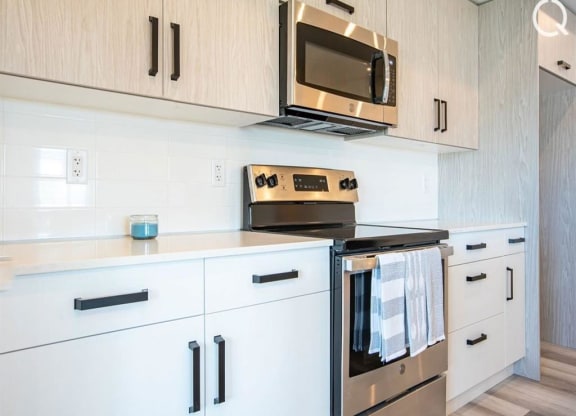 a kitchen with white cabinets and a stove and a microwave