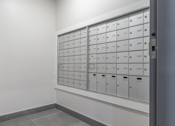 a wall of lockers in a room with white walls and flooring