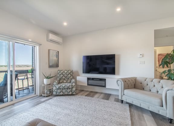 a living room with a couch and a tv and a balcony