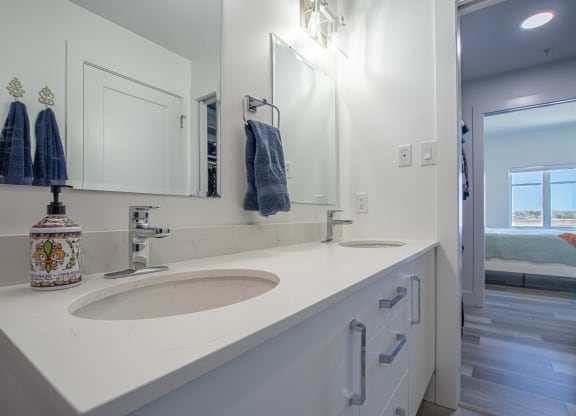 a white bathroom with two sinks and a mirror