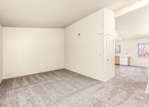 Living room and kitchen of an apartment with carpeting and white walls at Meadowview Apartments, Santa Rosa, CA