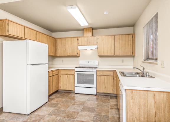 Kitchen with white appliances and wooden cabinets at Meadowview Apartments, Santa Rosa, CA