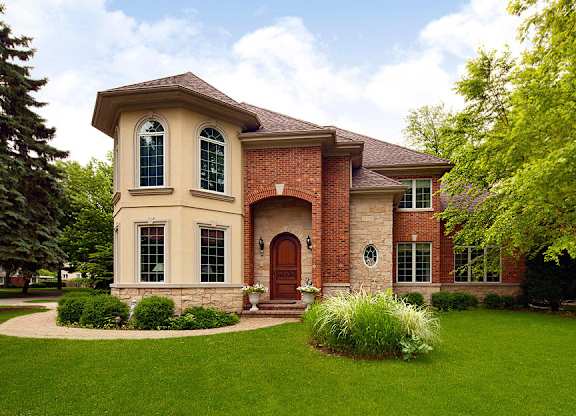 A house with a red brick facade and a brown roof.