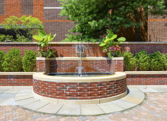 a fountain in a courtyard in front of a brick building at HIGHGROVE, Stamford, Connecticut