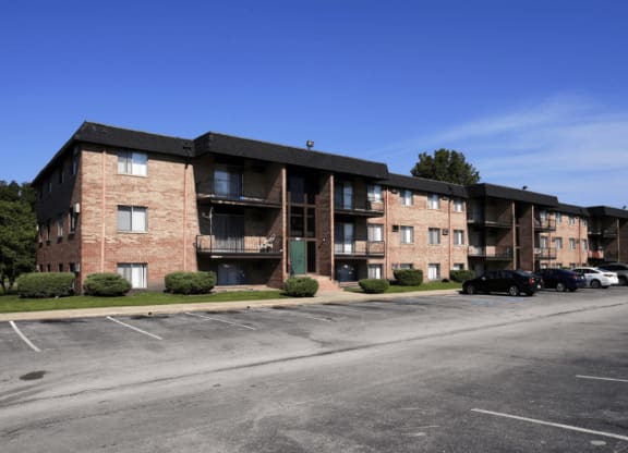 an apartment complex with a parking lot in front of it