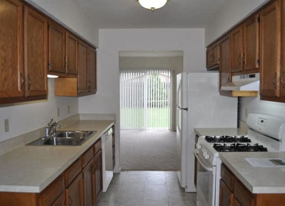 a kitchen with a white refrigerator freezer next to a stove top oven