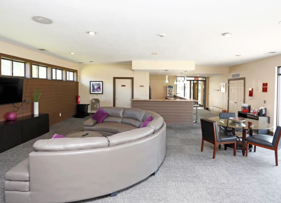 a living room with a large couch and a table with chairs