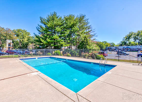 A swimming pool surrounded by a fence and trees.