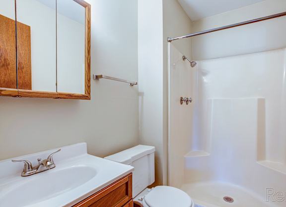 A white bathroom with a sink, toilet, and bathtub.