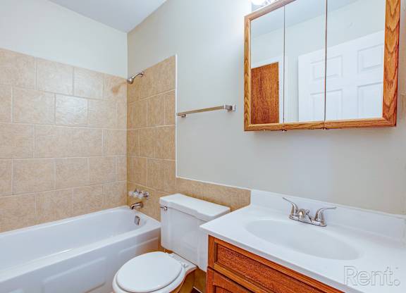 A bathroom with a tub, toilet and sink.