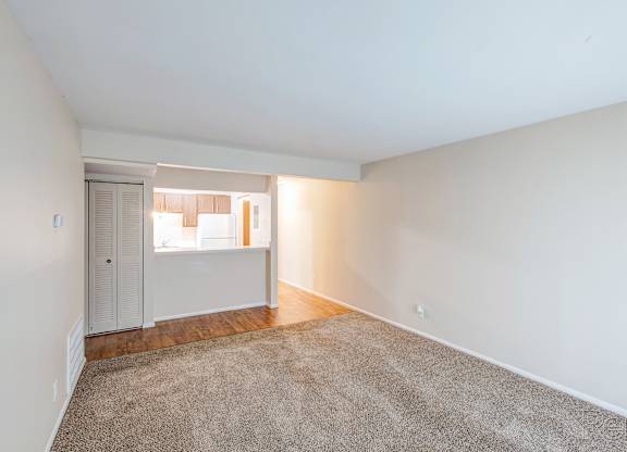 A room with a carpeted floor and a door leading to another room.