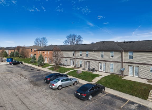 an aerial view of an apartment complex with cars parked in a parking lot