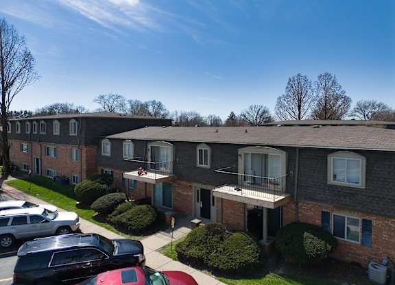 an aerial view of a brick apartment building with a parking lot