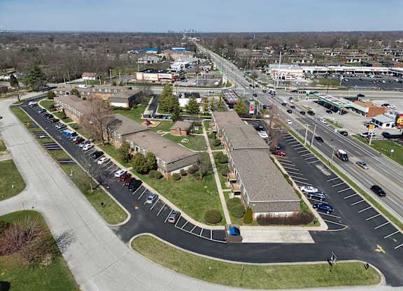 an aerial view of a parking lot with several buildings and a highway