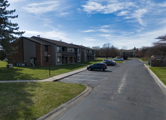 an apartment complex with cars parked in a parking lot