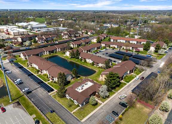an aerial view of a neighborhood with houses and a pond