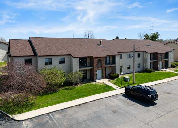 a large apartment building with a black car parked in front