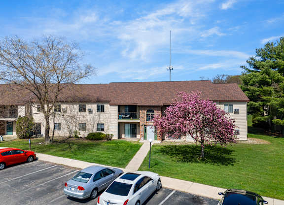 the front of a building with cars parked in a parking lot