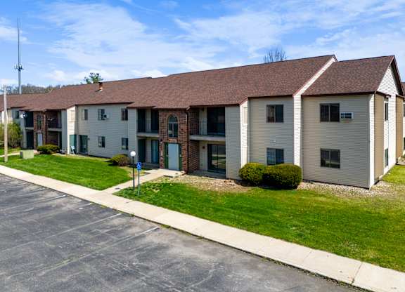 an apartment building with a sidewalk and grass