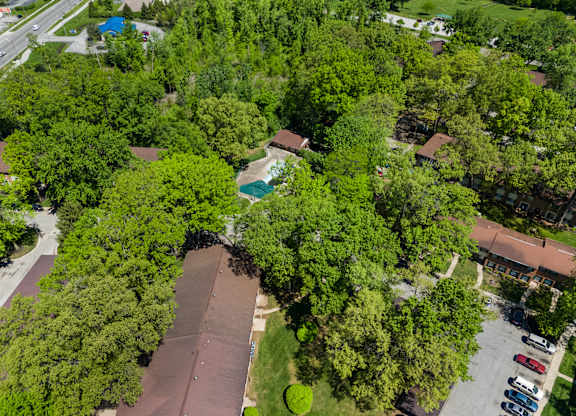 an aerial view of a neighborhood with trees and a parking lot