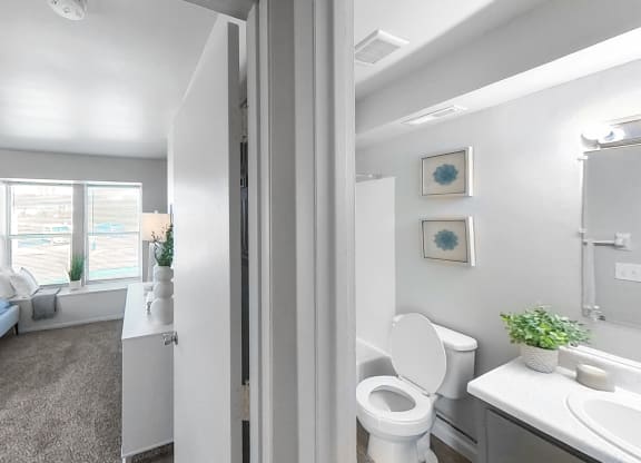a bedroom with a bed and a bathroom with a toilet and a sink