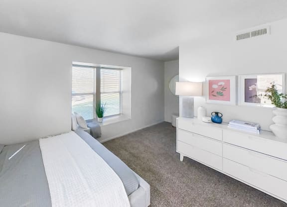a bedroom with a bed and a dresser and a window