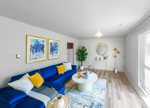 a living room with a blue couch and a round table