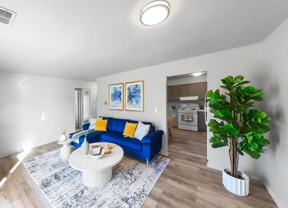 a living room with a blue couch and a white table
