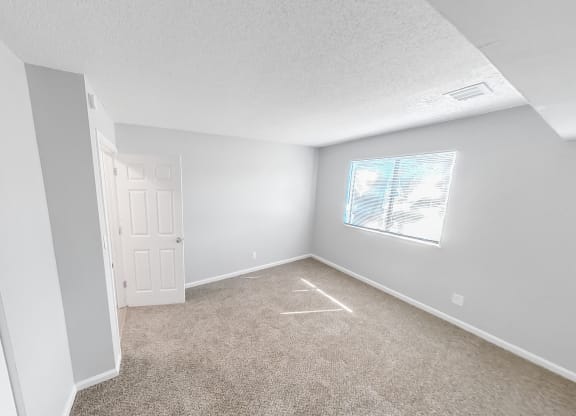 an empty room with carpet and a window