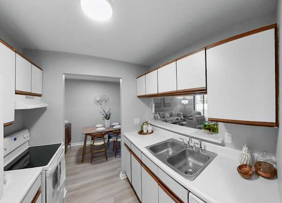 a kitchen with white counter tops and a stainless steel sink