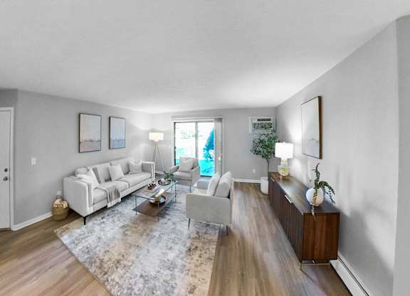 a living room with white couches and a rug