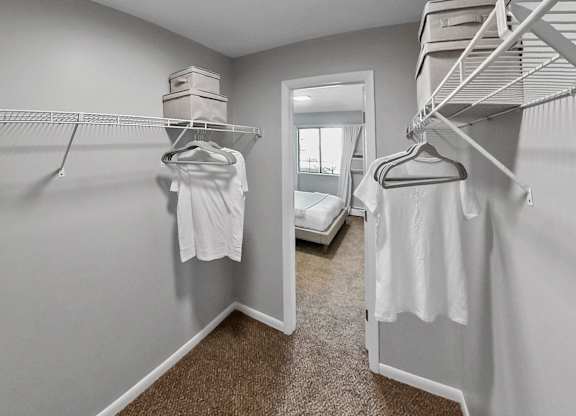 the walk in closet has two closets and two white dresses