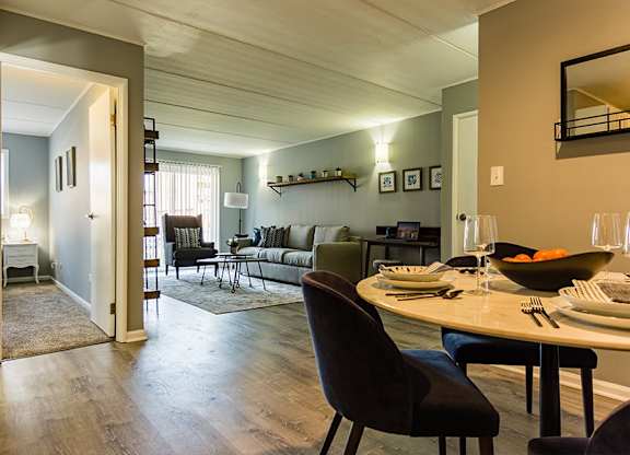 a living room and dining room with a table and chairs