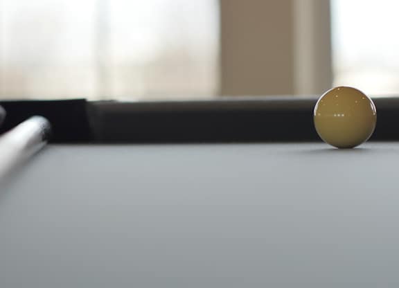 A pool table with a white ball on it.