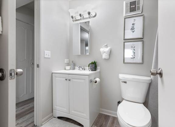 a white bathroom with a toilet and a sink