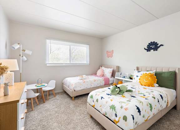 a bedroom with two twin beds and a desk