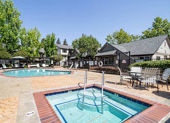 A pool with a slide and a hot tub.