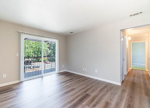 A room with a sliding glass door leading to a patio.