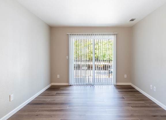 A room with a sliding door leading to a balcony.