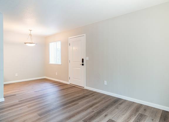 A room with a wooden floor and a white door.